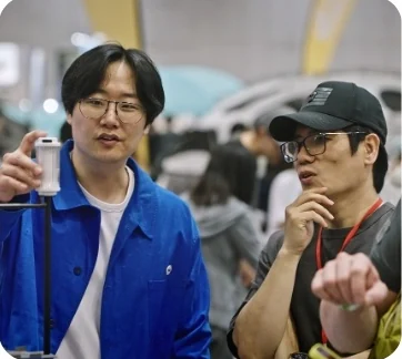 전시에서 캠핑 소품을 들어 설명하는 모습