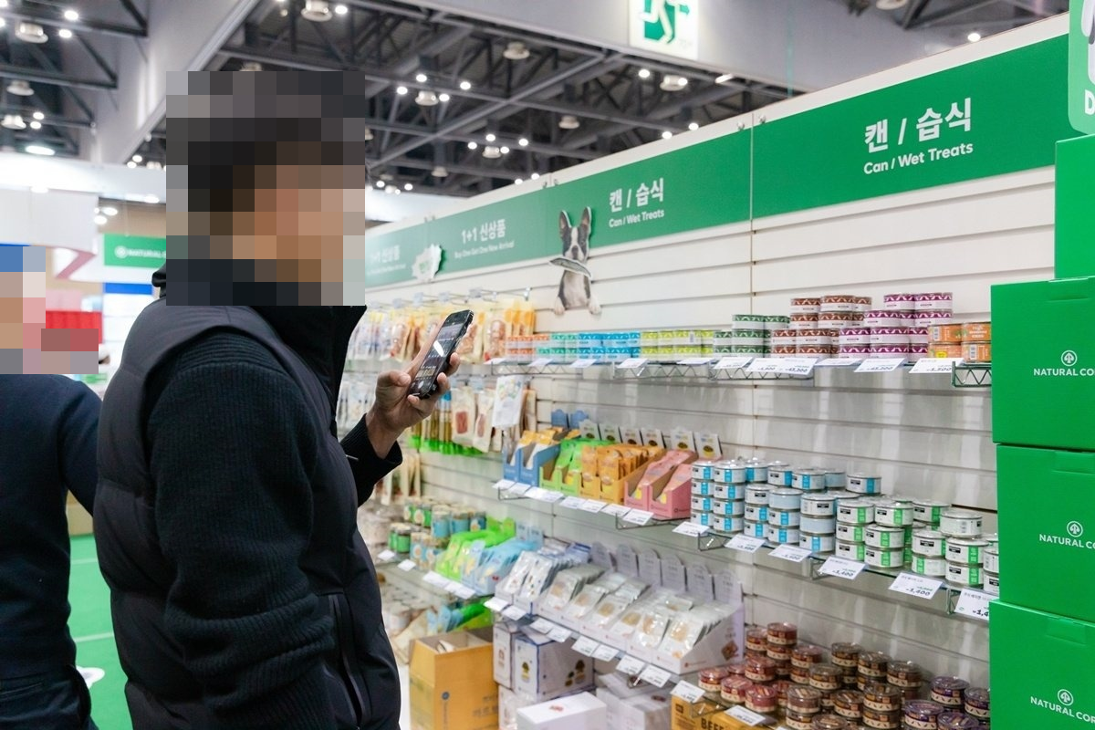 이전 메가주 전시에서 사료·간식 제품이 진열된 부스를 살펴보는 관람객